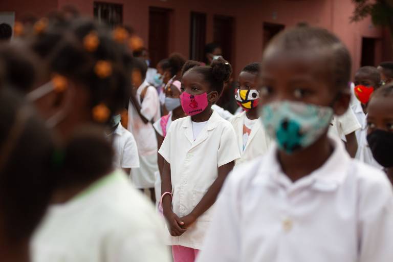 Em Luanda, capital da Angola, crianças recebem as instruções de como se comportar em sala de aula para prevenir as infecções por Covid durante a reabertura das escolas no país lusófono