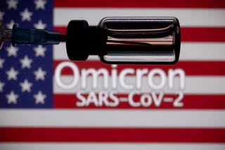 FILE PHOTO: A vial and a syringe are seen in front of a displayed United States' flag and words 