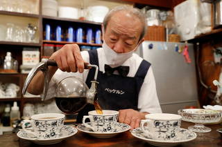 Shizuo Mori, the owner of Heckeln coffee shop brews coffee with a Syphon coffee maker at his shop in Tokyo