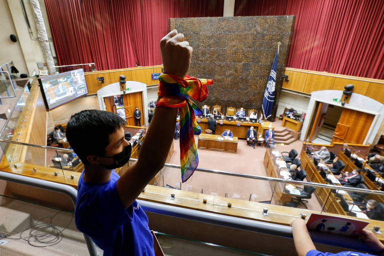 Ativista com lenço com as cores do arco-íris, celebra aprovação do casamento gay no Senado chileno, em Valparaíso