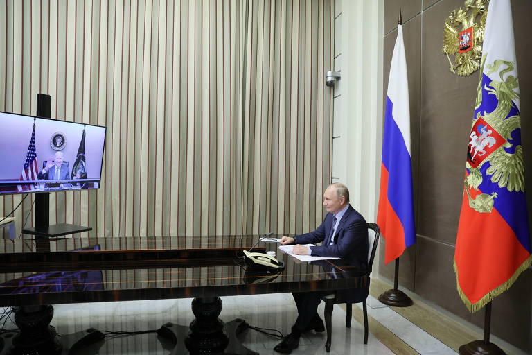 Pelo monitor, Joe Biden acena a Vladimir Putin no começo da conversa dos dois presidentes