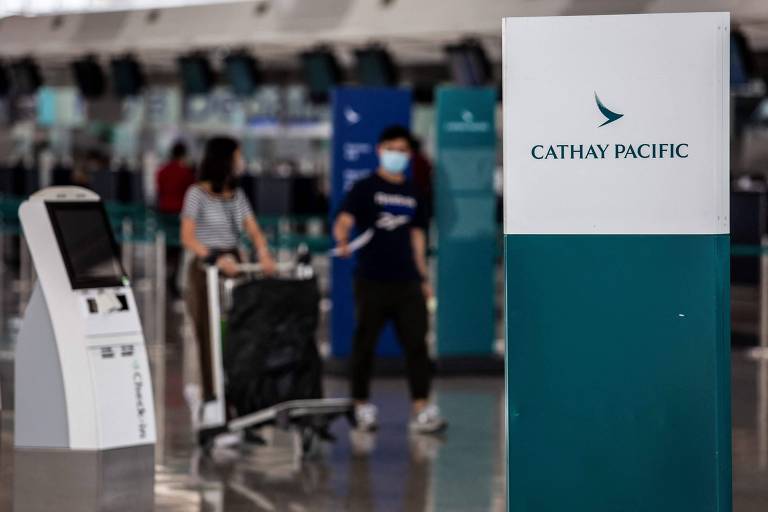 Passageiros passam pelos balcões de check-in da Cathay Pacific, no aeroporto internacional de Hong Kong
