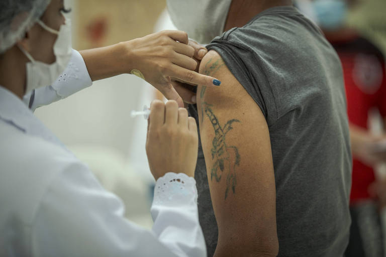 Profissional de saúde aplica vacina contra Covid em homem em São Paulo