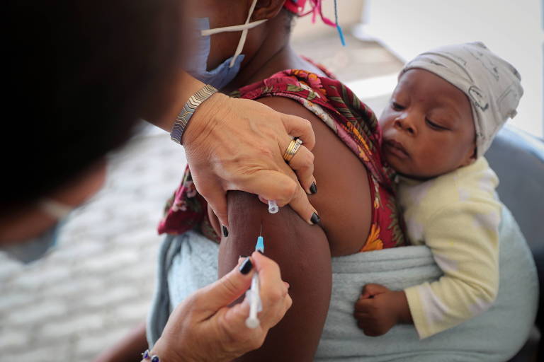 Enfermeira vacina uma mulher em Johanesburgo, na África do Sul, onde primeiro foi confirmada a variante ômicron da Covid-19