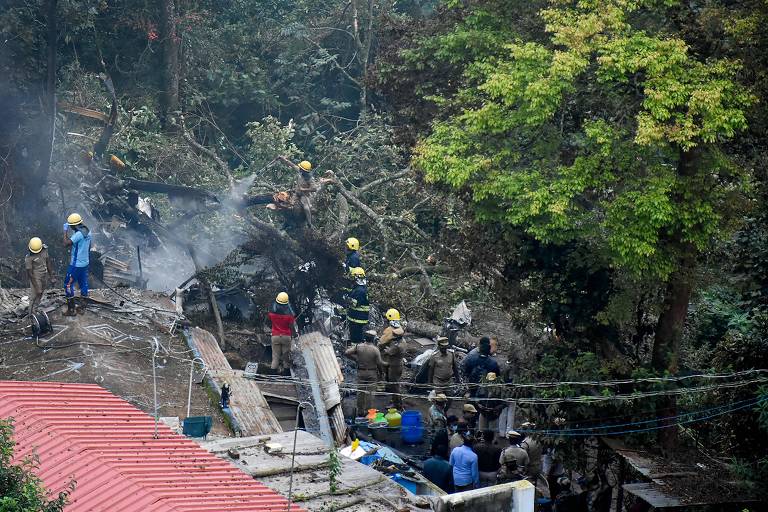 Bombeiros e equipes de resgate trabalham na encosta onde o helicóptero que transportava o chefe das Forças Armadas caiu, em Coonoor, no estado de Tamil Nadu, na Índia