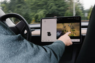 Vince Patton demonstrates that it is possible to play video games on his Tesla's screen while driving, in Portland, Ore. on Sept. 17, 2021. (Will Matsuda/The New York Times)
