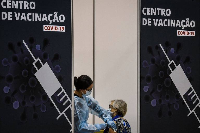 Mulher é vacinada em Lisboa (POR); na Europa, mais de 600 milhões de doses já foram administradas 