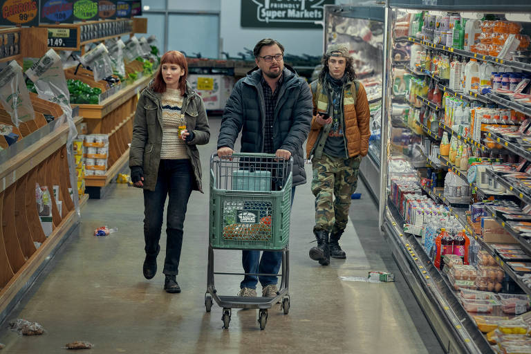 Personagens andam em supermercado, um lado do outro, com DiCaprio empurrando um carrinho de mercado, e olhando em volta