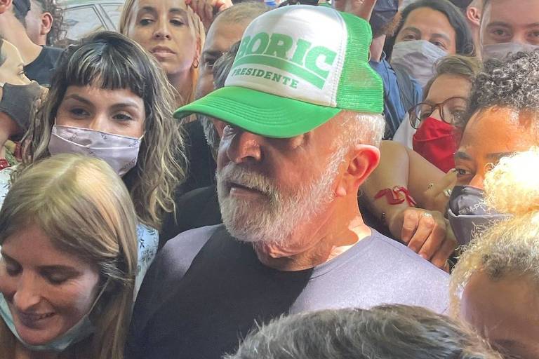 O ex-presidente Lula rodeado, por uma multidão, usa boné verde 