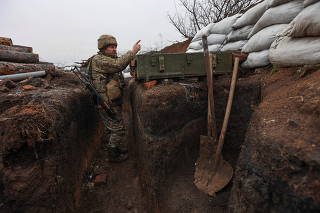 Service members of the Ukrainian armed forces stand guard at combat positions near Zolote
