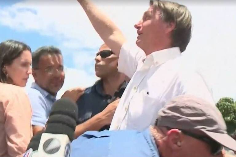 Bolsonaro ergue o braço cercado de apoiadores