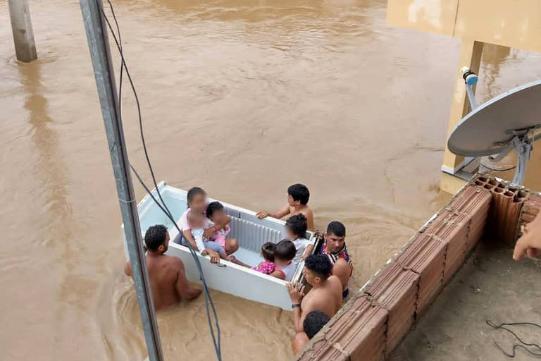 Foto mostra crianças e adultos sendo resgatados