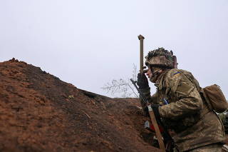 Service members of the Ukrainian armed forces stand guard at combat positions near Zolote