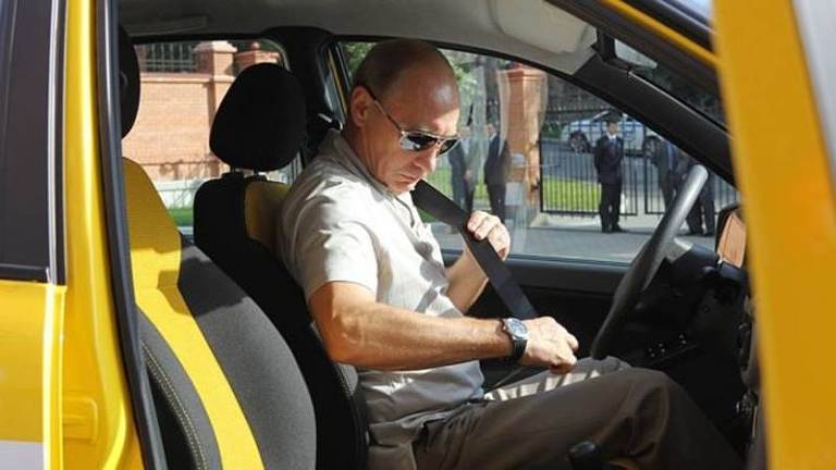 Vladimir Putin coloca cinto de segurança em veículo amarelo