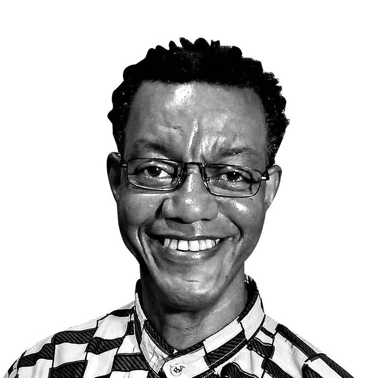 homem negro sorri em foto preto e branco