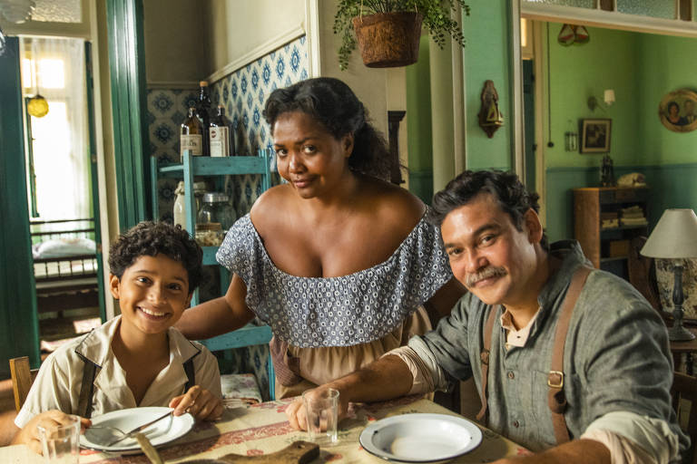 Gaby Amarantos é Emília em 'Além da Ilusão'; na foto, a personagem aparece ao lado de seu filho, Jojo (Nicolas Parente), e seu marido, Cipriano (Claudio Gabriel)