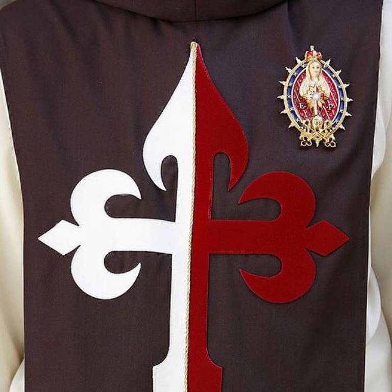 A túnica usada pelo grupo tem uma cruz que remete a cavaleiros medievais