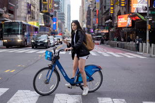 Woman rides bicycle in her shorts through Times Square, New York City