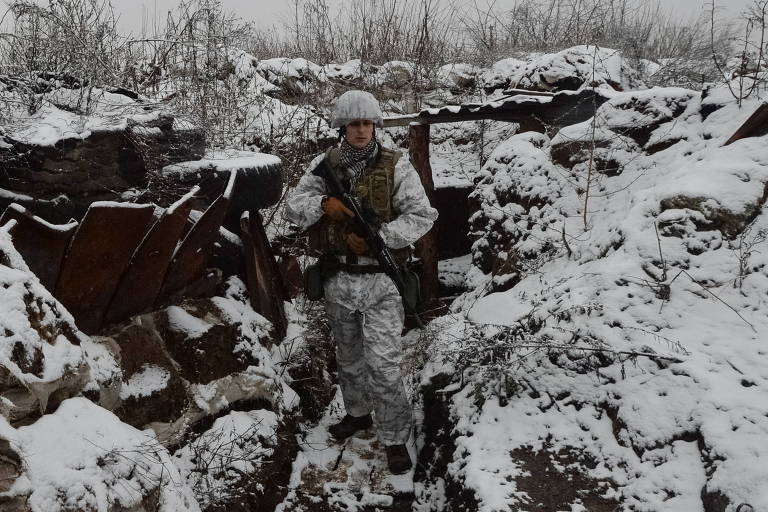 Soldado ucraniano em trincheira sob a neve na linha de frente em Avdiivka, na região de Donetsk
