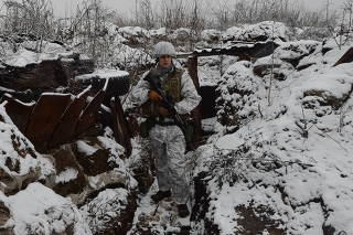 Ukrainian service member stands in a trench on the front line in Avdiyivka