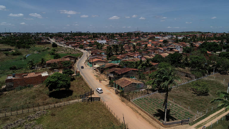 Imagem de uma estrada em Cangandu, comunidade em Arapiraca, Alagoas: metade da estrada está pavimentada, a outra metade ainda é estrada de terra. 