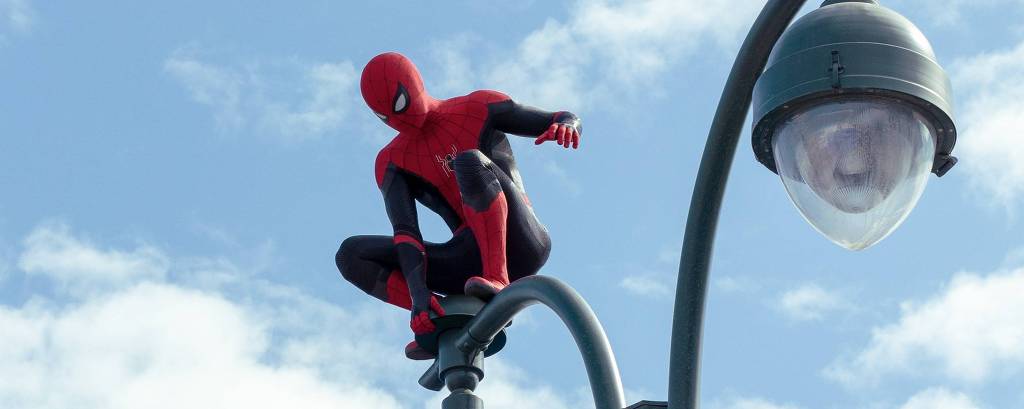 Spider-Man perched atop a light in Columbia Pictures' SPIDER-MAN: NO WAY HOME.