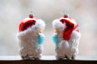 Christmas baubles shaped as Santa Clauses wearing protective masks are pictured in Eichenau