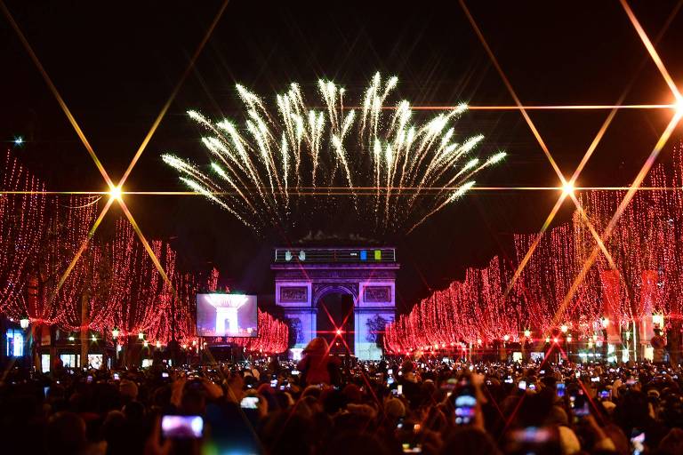Multidão assiste a fogos de artifício sobre Arco do Triunfo