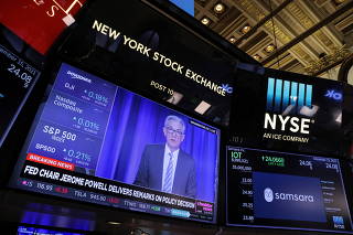 Federal Reserve Chairman Jerome Powell delivers remarks on a screen at the trading floor at the New York Stock Exchange (NYSE) in Manhattan