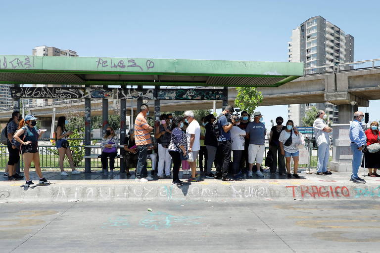 Pessoas esperam em parada de ônibus para usar o transporte público, em Santiago
