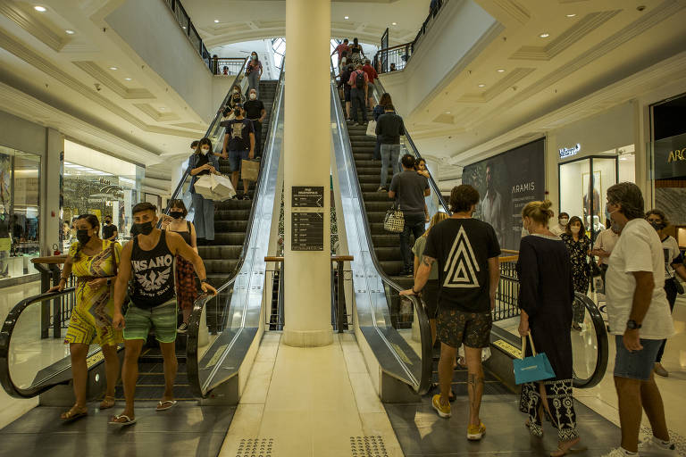 Pessoas em escada rolante de shopping