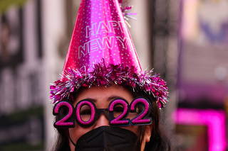 Teresa Hui, 40, of Brooklyn, wears 2022 numeral glasses and a face mask in Times Square ahead of New Year's Eve celebrations in Manhattan, New York City