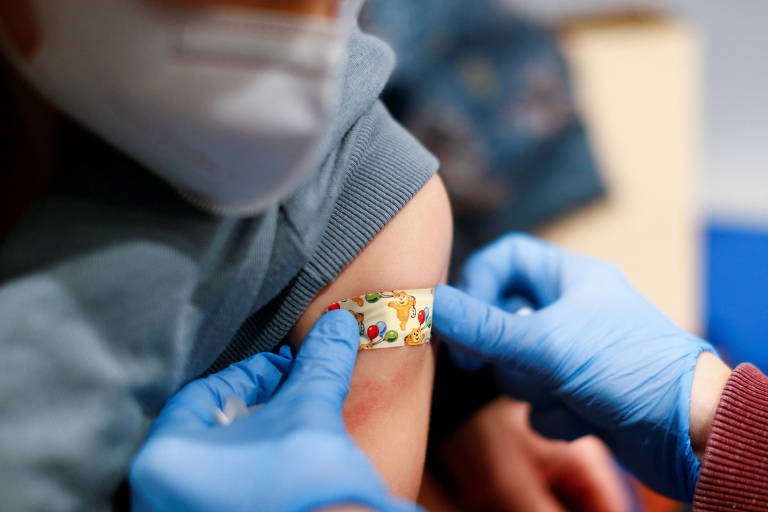 Criança ganha um band-aid colorida após a dose da vacina da Pfizer-BioNTech contra a Covid-19