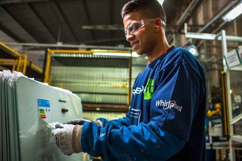 Colaborador coloca selo de eficiência energética na fábrica da Whirlpool em Rio Claro