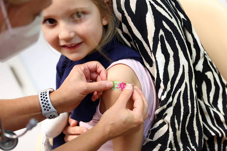 Criança sorri após receber a dose da vacina da Pfizer contra a Covid-19 na Alemanha 