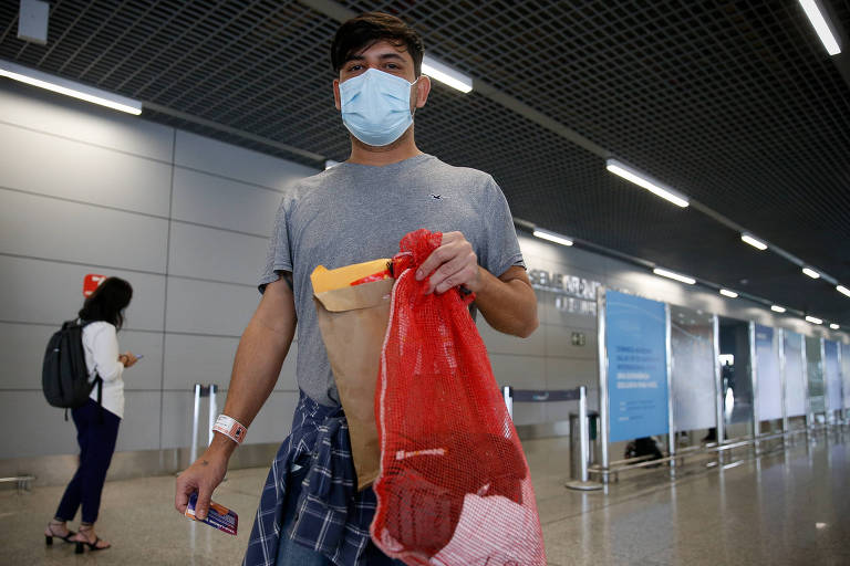 Jhonatan Nogueira da Silva, 35, no aeroporto de Confins (MG); ele foi deportado e chegou ao Brasil com os pertences dentro de um saco laranja