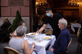 People eat at a restaurant in Manhattan, New York