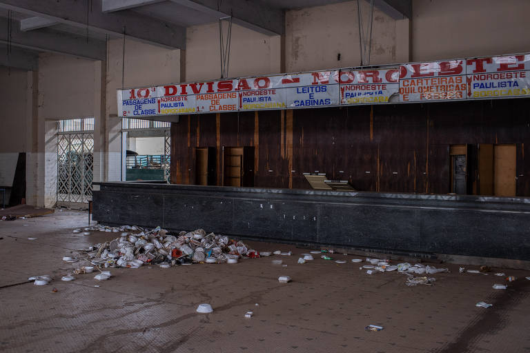 Interior de estação de trem de Bauru, com dezenas de marmitex no chão