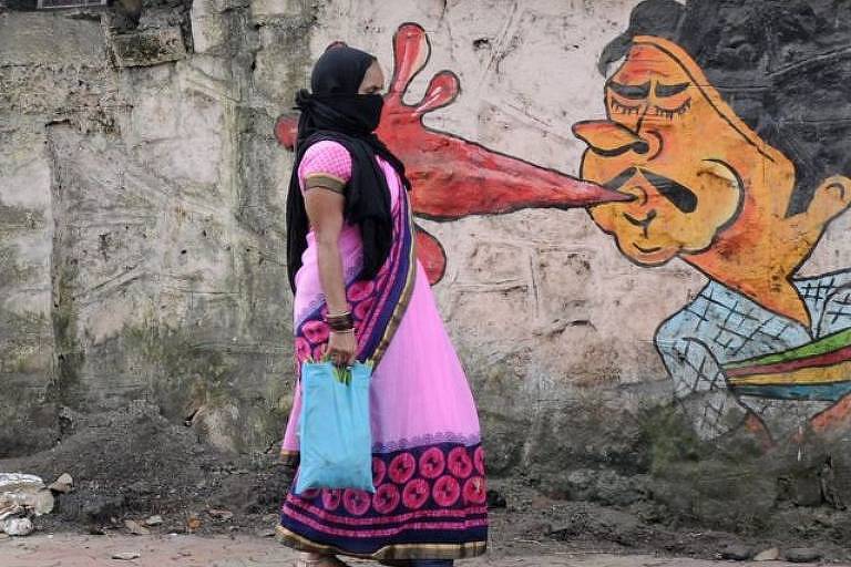 Mulher andando na rua com um grafite de um homem cuspindo