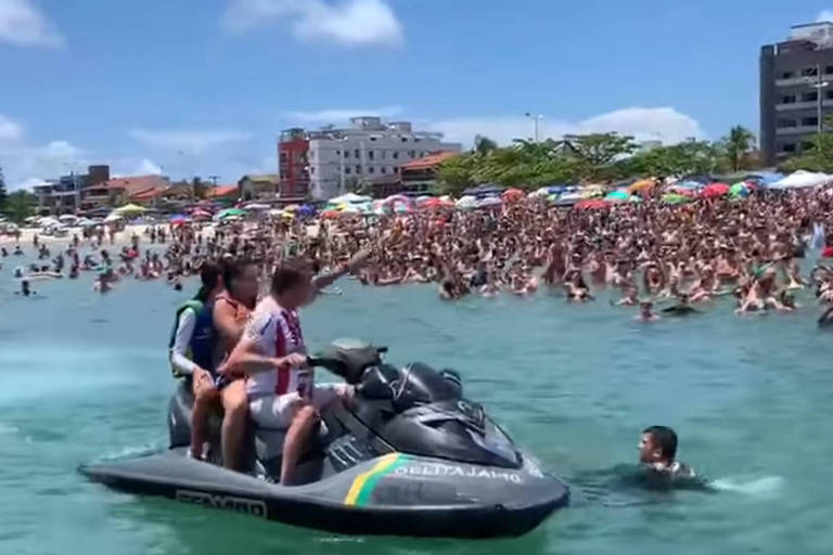  Presidente Jair Bolsonaro acenando pros banhistas, na  Praia da Enseada,  onde passa férias