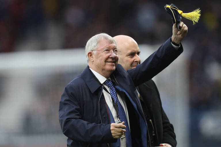 Sir Alex Ferguson acena para o público ao ser homenageado antes de partida entre Escócia e Israel, em Glasgow