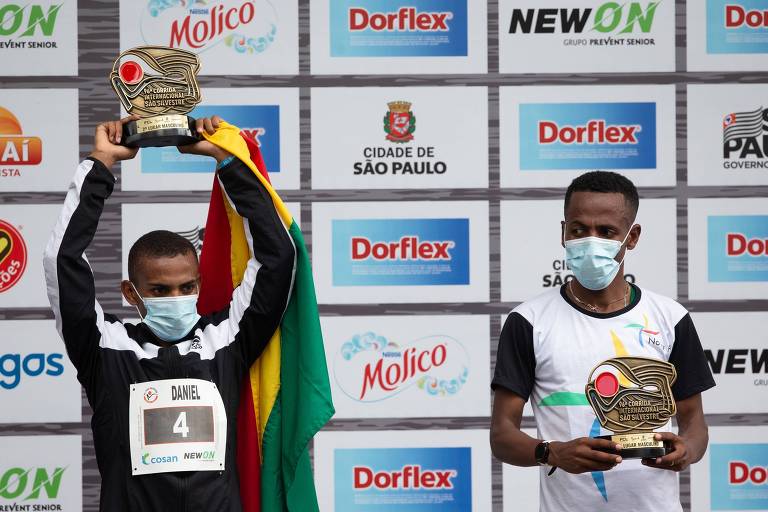 Daniel Nascimento (à esq.) e o etíope Belay Bezabh no pódio da 96ª Corrida de São Silvestre; brasileiro ficou em 2º lugar, atrás do africano