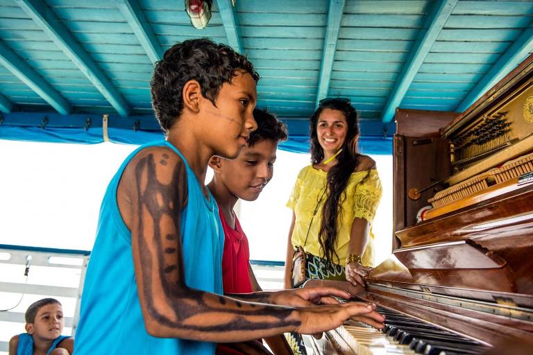 Pianista toca para ribeirinhos em barco na Amazônia