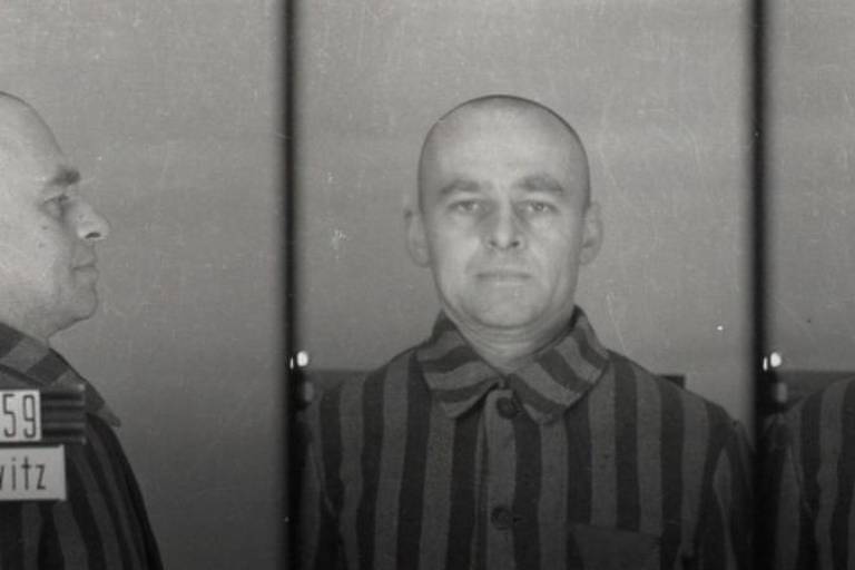 Foto em preto e branco de ficha policial mostra homem careca, com roupa listrada