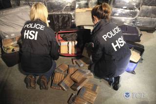 Homeland Security special agents examine seized drugs in a highly sophisticated tunnel used to smuggle drugs between the U.S. and Mexico
