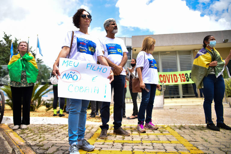 Grupo de pais com cartaz em que se lê "meu filho não e cobaia"