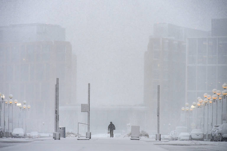 Pessoa caminha em meio à nevasca em Washington; escritórios do governo federal dos EUA e escolas na região foram fechadas devido à tempestade de inverno