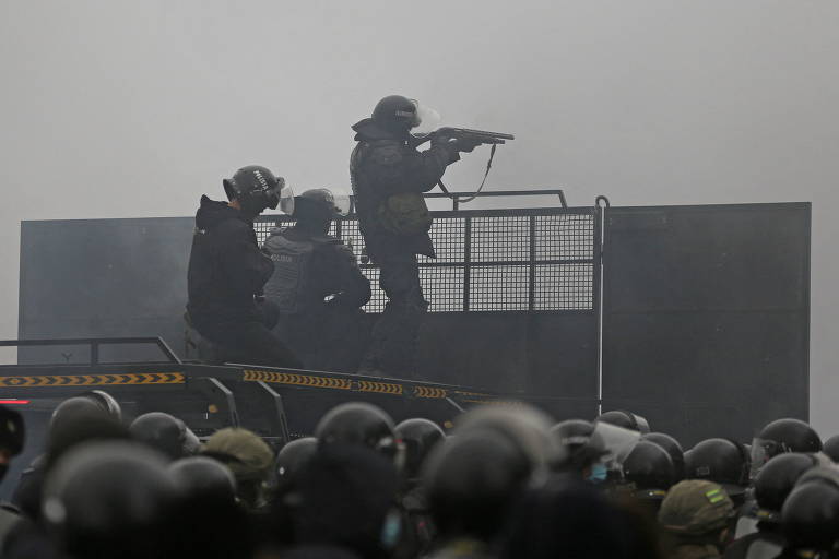 Policiais cazaques numa barricada contra manifestantes em Almati
