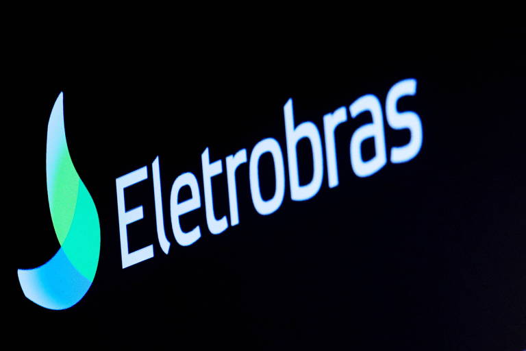 Fotografia mostra um logo branco da Eletrobras, com um ícone de chama ao lado na cor azul e verde