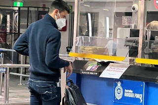 Serbian tennis player Novak Djokovic stands at a booth of the Australian Border Force at the airport in Melbourne